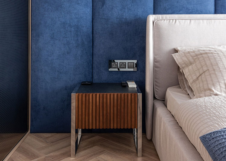 brązowa szafka nocna w zestawieniu z niebieską ścianą w sypialni