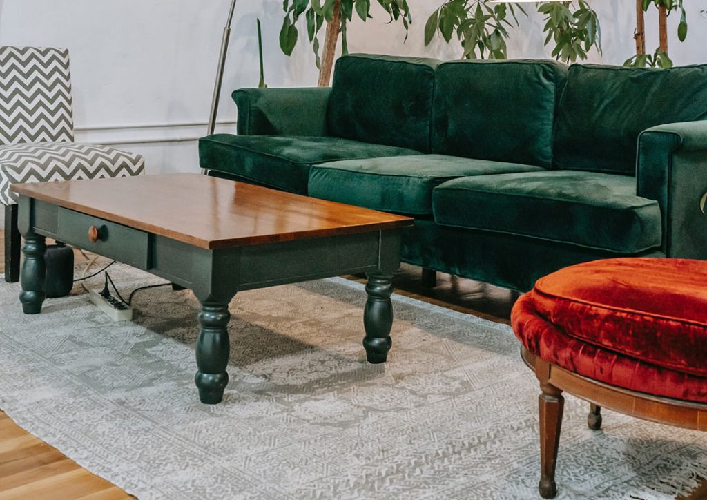 zielona sofa i czerwony tapicerowany fotel w salonie
