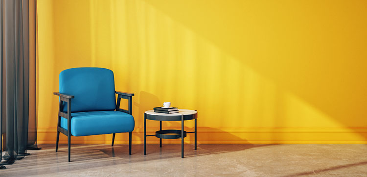 niebieski tapicerowany fotel w salonie ze ścianami w kolorze zółtym
