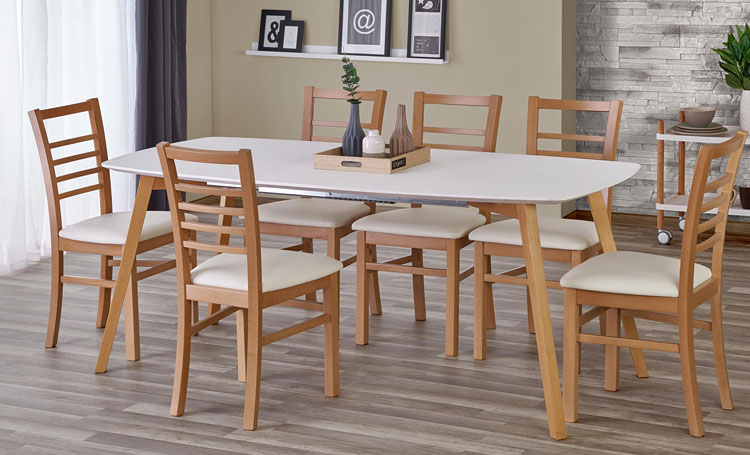 biały stół zestawiony z drewnianymi krzesłami. 